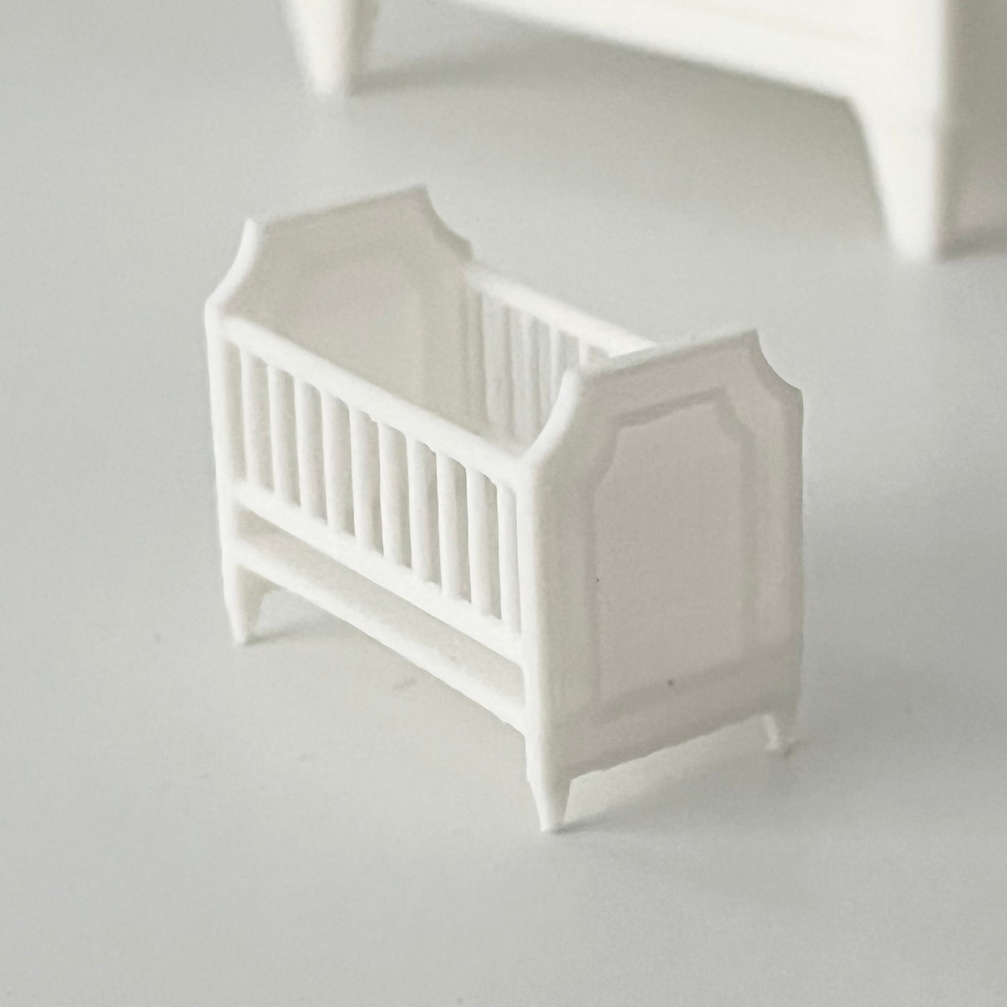 A close up of a 1:48 miniature scale crib
