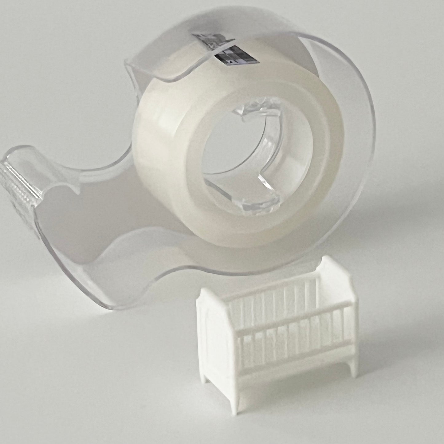 White baby crib in 1:48 scale in front of a regular size tape dispenser