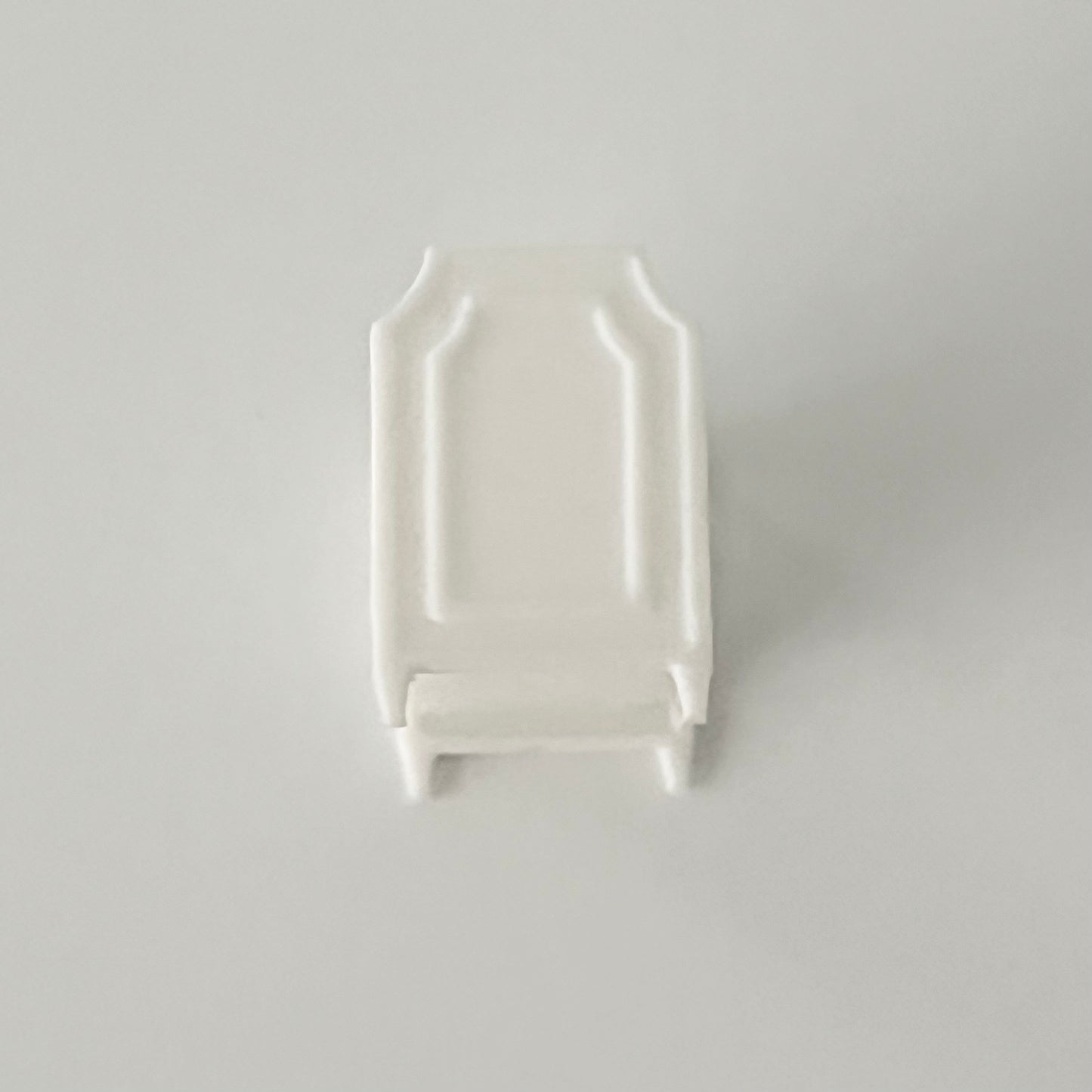 A front view of White baby crib in 1:48 scale on a light gray background